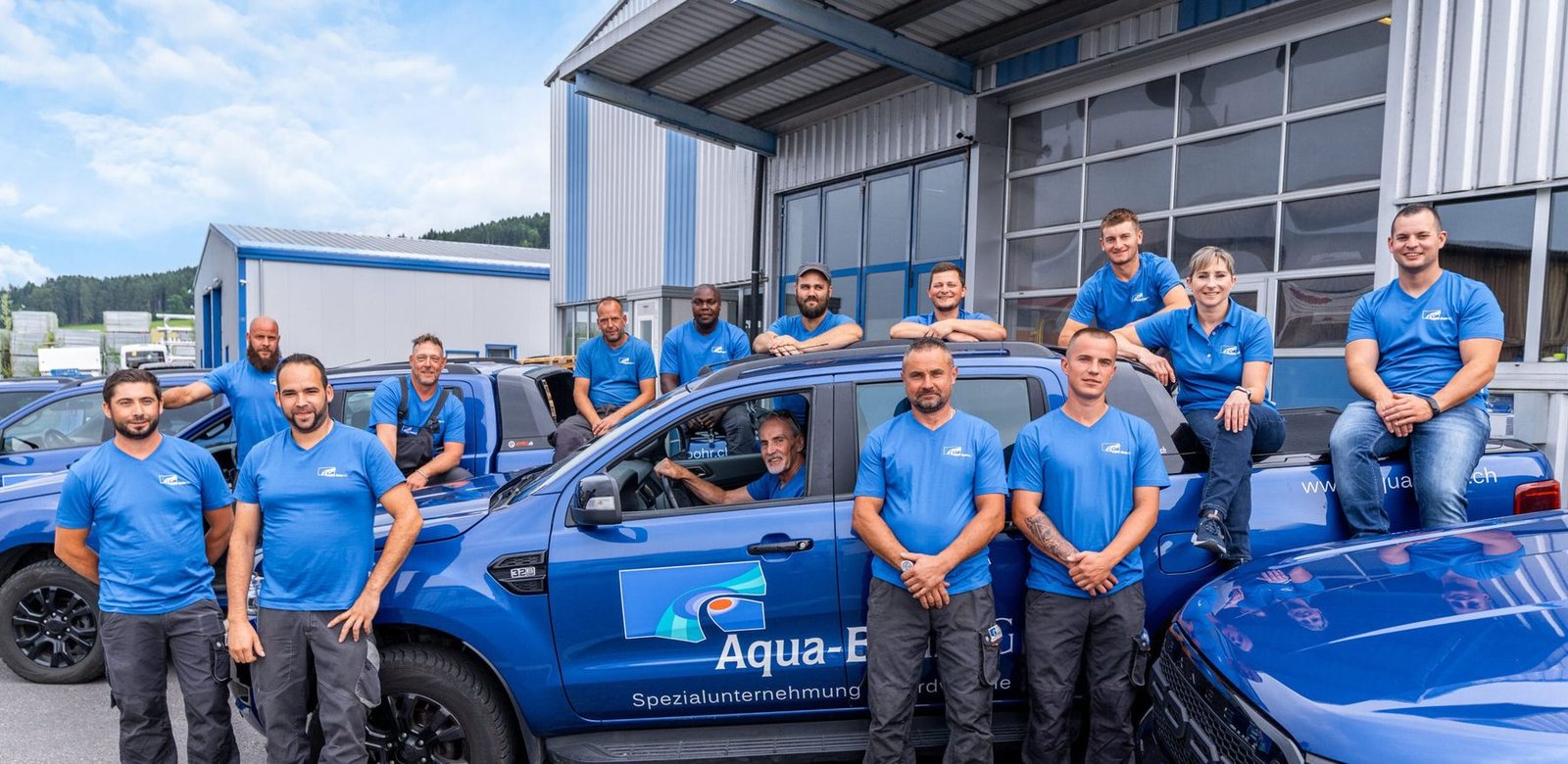 Team der Aqua-Bohr AG vor den Firmenfahrzeugen